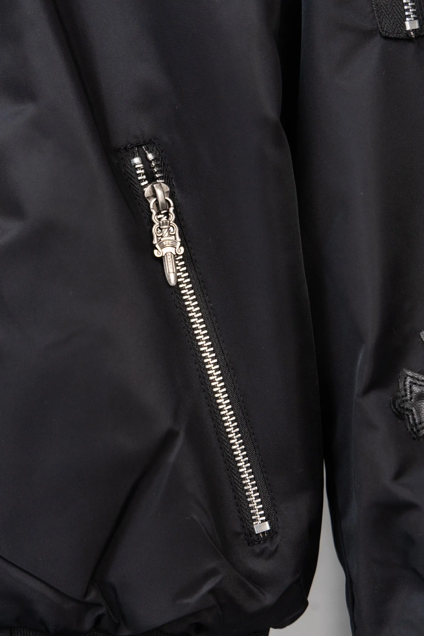 P410 Style No.: S045 This is a velvet baseball jacket from **Chrome Hearts**. It is a representative item of the brand that combines dark pioneer style with American street culture. It is also a trendy item that combines personality and warmth in autumn and winter. Design Highlights Iconic Elements: The brand’s classic cross leather embroidery is embellished throughout the body, paired with metallic hardware decorations (such as zipper pullers and hang tags). It combines Gothic religious symbols with heavy metal style, which is highly recognizable and is an intuitive embodiment of Crow Heart’s “dark luxury” tone.  Style and structure: It adopts the classic baseball uniform style, with a stand-up collar design and a two-way zipper, which is neat and stylish; the zipper pockets on the sleeves and the diagonal pockets on the body not only enhance the street feel, but are also practical.  Material splicing: The outer layer is made of high-density windproof fabric, and the inner layer is filled with velvet material, which has excellent thermal insulation performance; the threaded design of the collar and cuffs improves the overall crispness and wearing comfort. Craftsmanship and Quality: The cross is veneered using imported leather + hand-embroidered craftsmanship, with fine stitching and strong three-dimensional effect; the metal hardware has been distressed to give it a vintage and distressed texture, and the details reflect the brand's strict requirements for craftsmanship.  The velvet inner liner is evenly and fully filled, and the splicing process with the outer fabric is rigorous. It is not easy to deform after long-term wear, and has excellent warmth retention and durability. Style and Outfit This jacket is based on dark street style, and its black main tone is versatile and high-end. It can be paired with ripped jeans and Martin boots to create a cool street style in daily life; it can also be worn with a turtleneck sweater and a long coat on the outside. It can be layered to create layers, making it easily suitable for niche trendsetters, rock enthusiasts and other diverse style groups. It is an eye-catching item in the autumn and winter wardrobe that shows individuality. Size: s-XL Color: Black